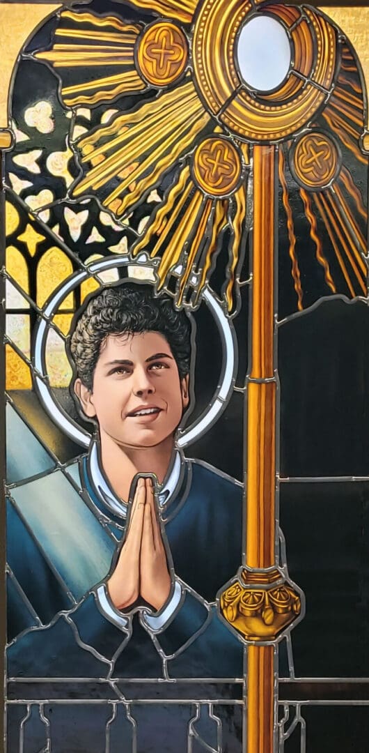 Stained glass window of a young man praying.