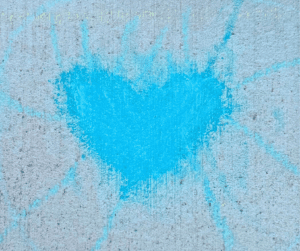 Blue heart painted on a concrete wall.