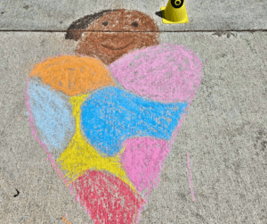 Chalk drawing of a person on sidewalk.